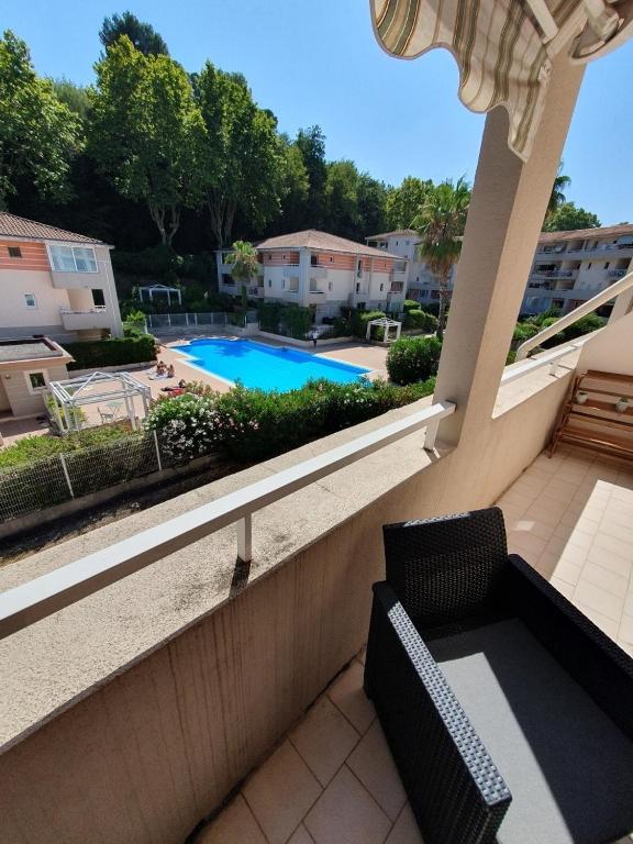 d'un balcon avec une chaise et une piscine. dans l'établissement 3 pièces au calme Terrasses Piscine et Tennis Garage, à Cagnes-sur-Mer