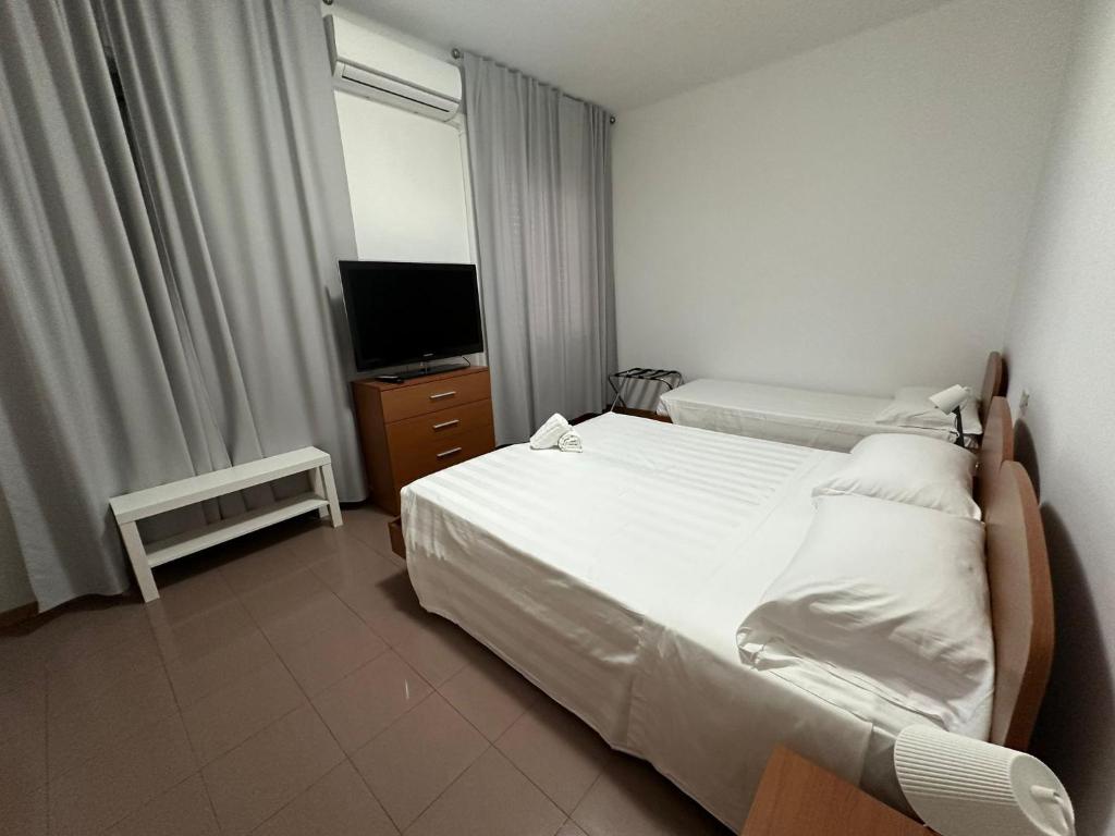 a hotel room with two beds and a television at Hotel la Marinella in Marina di Montemarciano