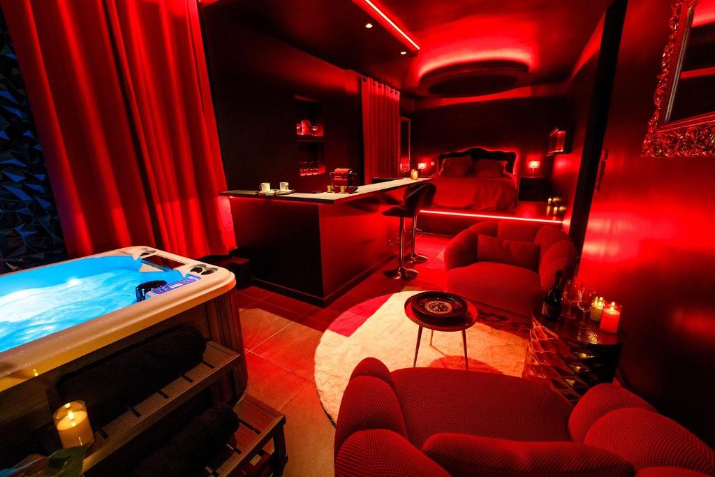 une chambre rouge avec une baignoire et des rideaux rouges dans l'établissement Suite Romantic - Love room - Toulouse centre, à Toulouse