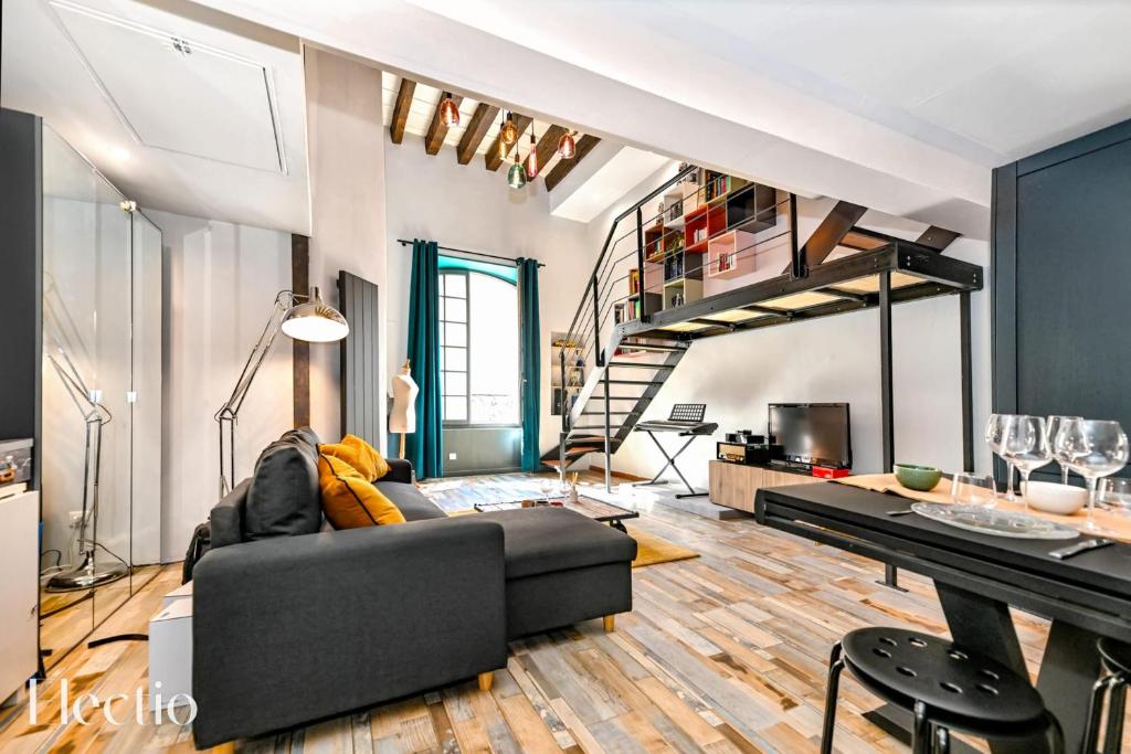 - un salon avec un canapé noir et un escalier dans l'établissement Apartment Petite Fusterie I Electio, à Avignon
