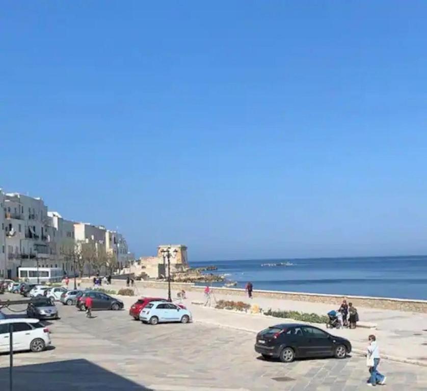 un parcheggio vicino alla spiaggia con auto parcheggiate di Mermaid a Trapani