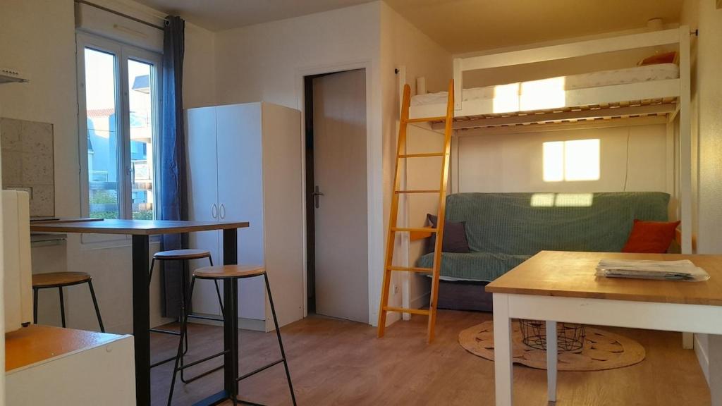 Cette petite chambre comprend des lits superposés et une table. dans l'établissement Studio 3 people Maritime Museum La Rochelle, à La Rochelle