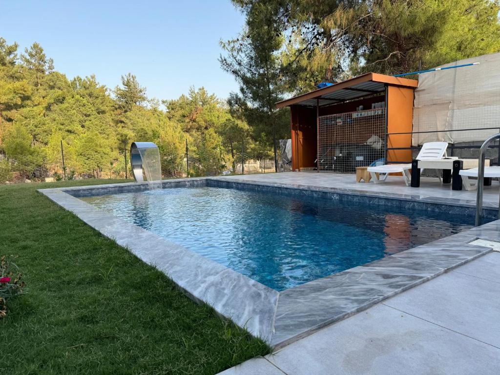 a swimming pool in a yard next to a house at Fethiye Çiftlik Villa in Fethiye