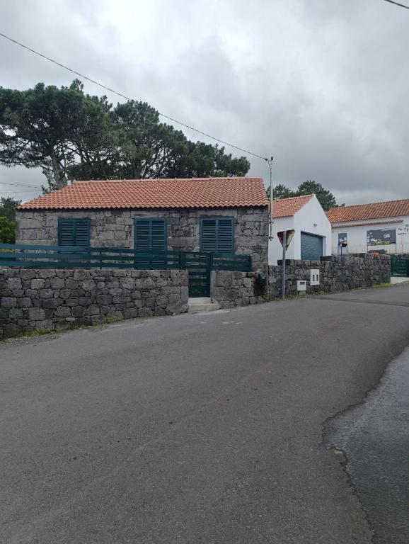 a house with a stone wall and a street at Casa da Miragaia in Maragaia