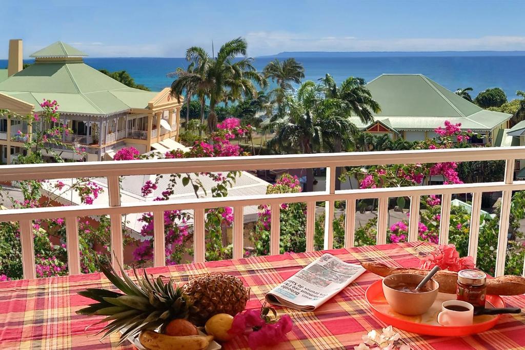 a table on a balcony with a view of the ocean at Appartement Coconut in Saint-François