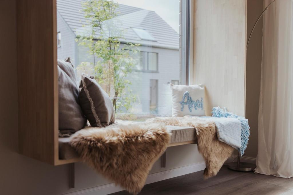 a window seat with a blanket and pillows at "Rügen Resort Sagard" großzügiges, gemütliches Familienhaus "Jördis" mit Terrasse in Sagard