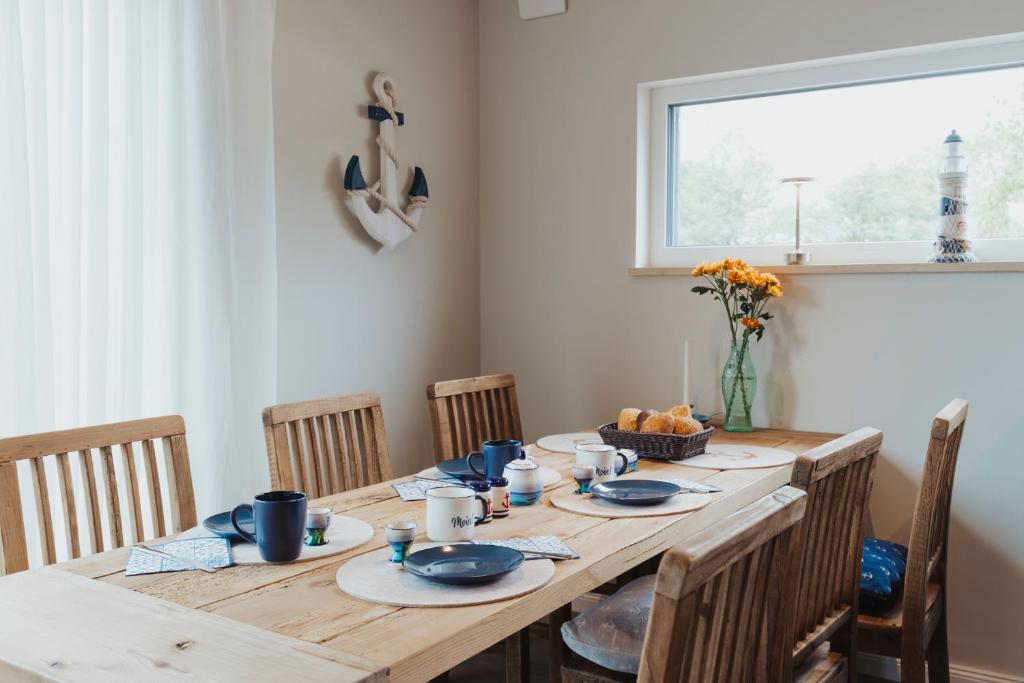 mesa de madera con sillas y comedor en NEU "Rügen Resørt Sagard" großzügiges, gemütliches Familienhaus "Line" mit Terrasse, en Sagard