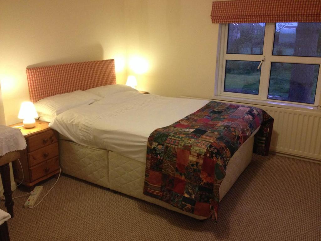 a bedroom with a large bed and a window at Lisieux House on Lough Neagh in Aghalee
