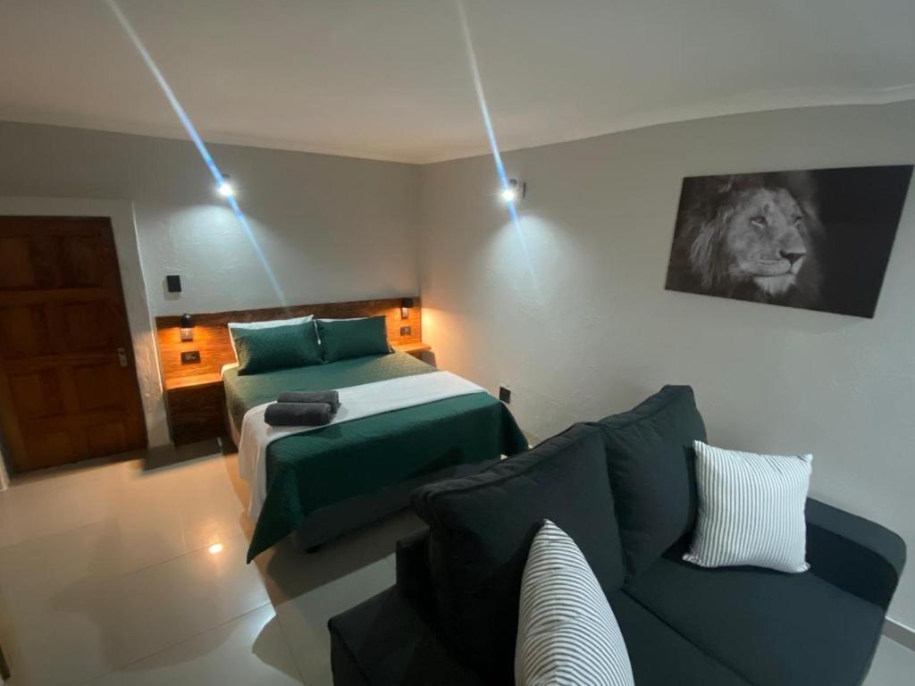 un soggiorno con divano e letto di The Hideaway a Nelspruit
