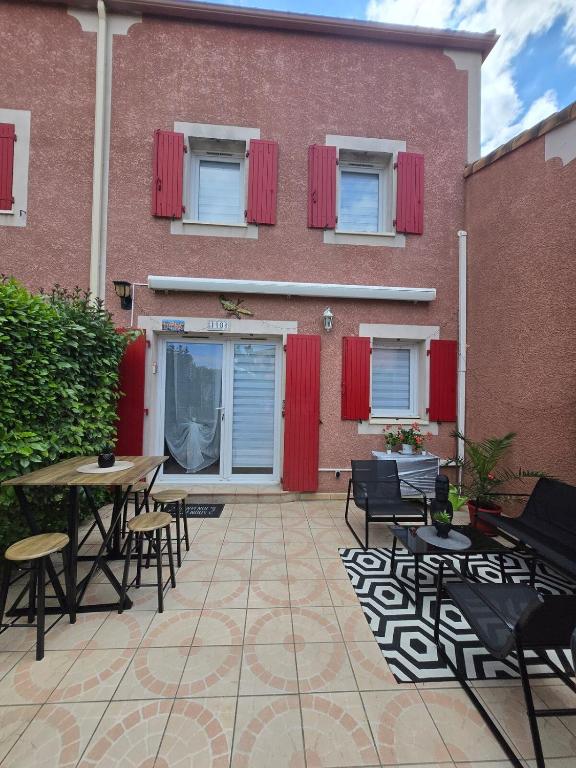 un patio avec des tables et des chaises en face d'un bâtiment dans l'établissement Lili Berges du Canal, à Béziers