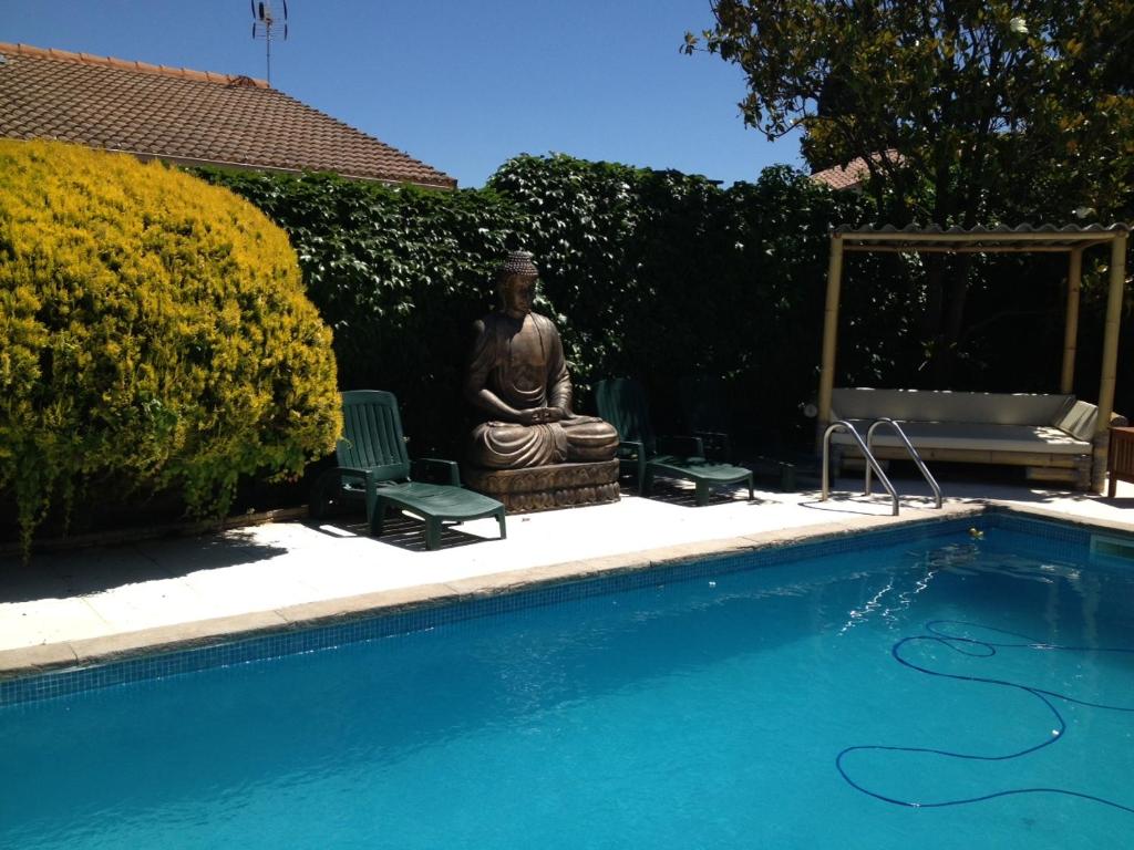 a statue next to a swimming pool with a statue at Villa ou studio indépendant PISCINE sans vis à vis in Mudaison