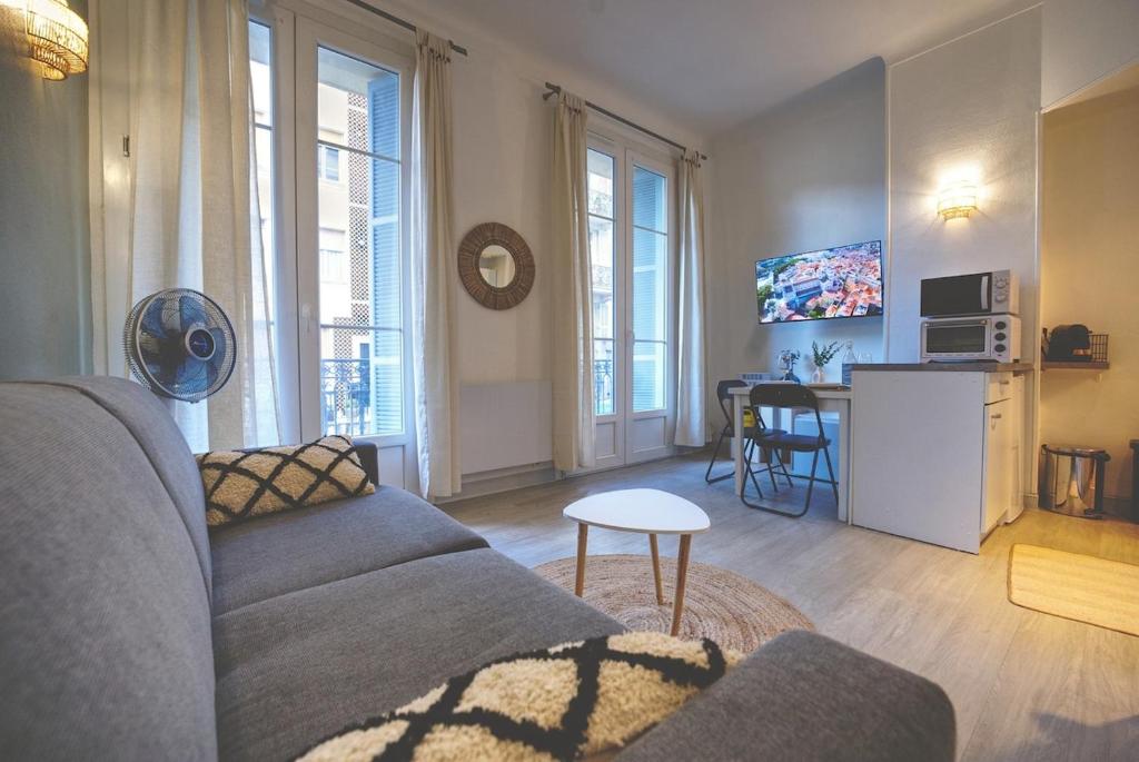 un salon avec un canapé et une table dans l'établissement Nouveau charmant Studio à 5 Minutes de la mer, à Nice