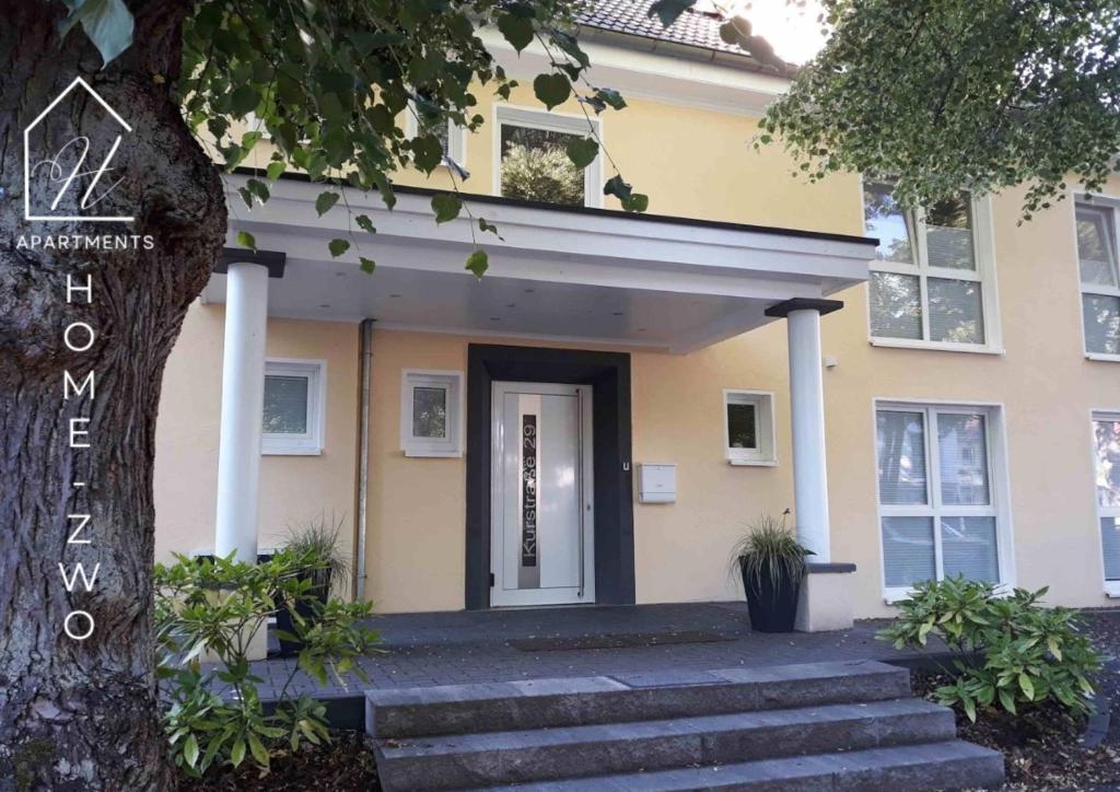 a yellow house with stairs in front of it at Home Zwo Apartments Bad Salzhausen Tiny 4 in Nidda