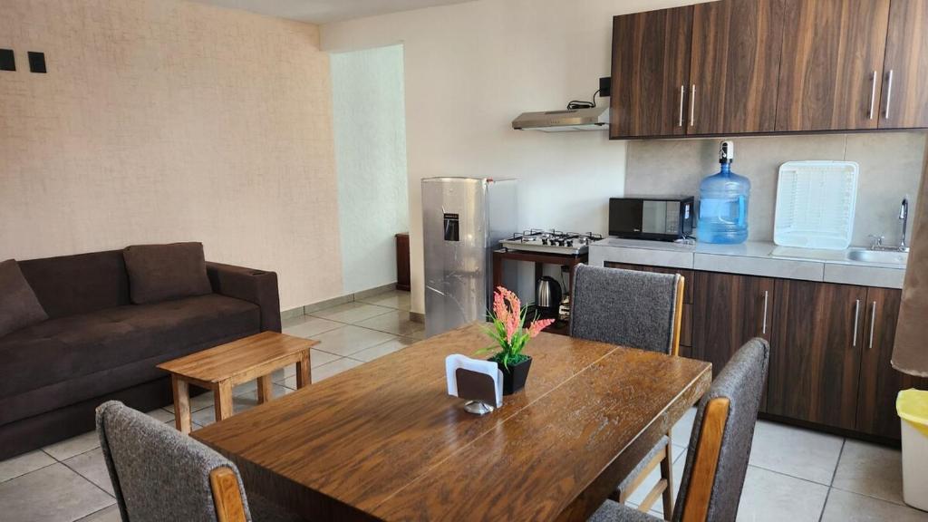 a kitchen and dining room with a table and a couch at Departamento Garcis in Morelia