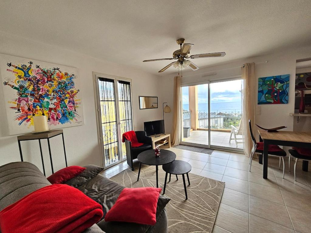 a living room with a couch and a table at Bel appartement Erbalunga- A deux pas de la plage in Brando