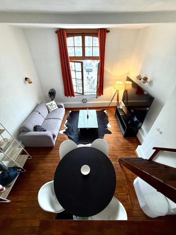 un salon avec une table et un canapé dans l'établissement Beffroi's Cosiest Place, à Arras