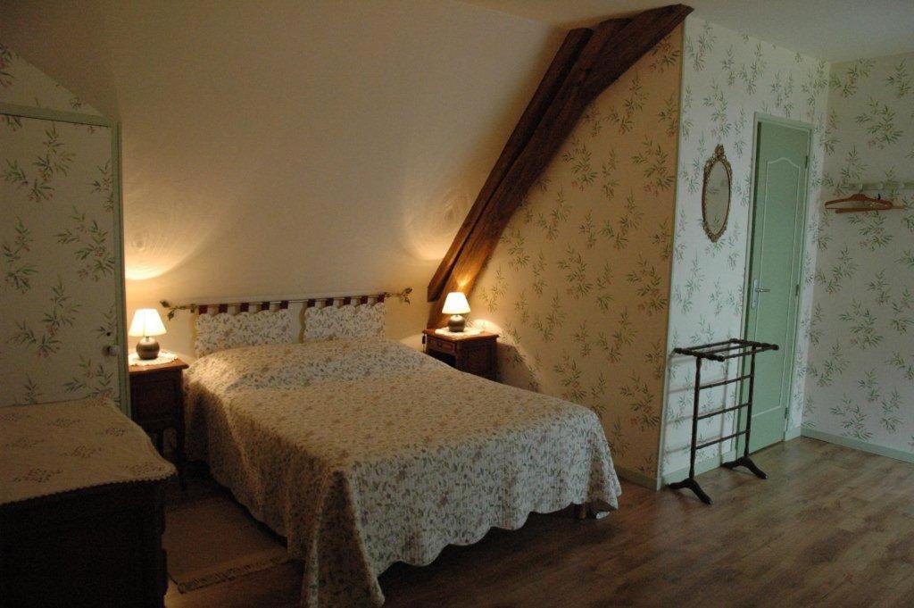 MorlacChambre d'hôte La Berthoderie的一间卧室设有一张床、两盏灯和一个楼梯。