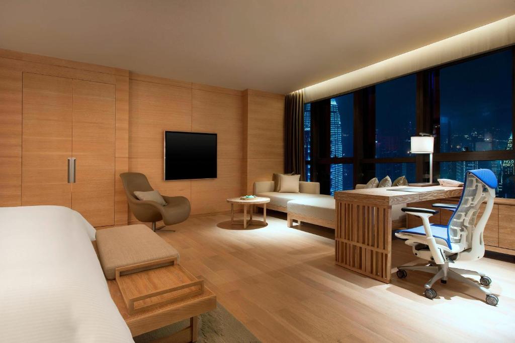a hotel room with a bed and a desk and a room with a desk at The Westin Chongqing Liberation Square in Chongqing