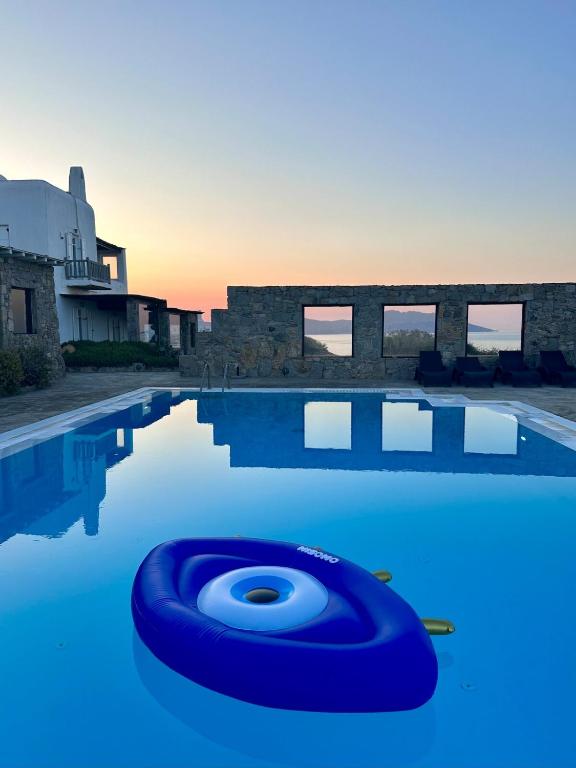 a swimming pool with a blue raft in the water at Villa Ruffi Mykonos in Mikonos