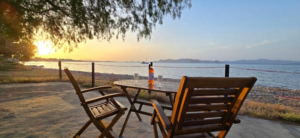 a table with two chairs and a bottle of wine at Eva's Beachfront House in Kos Town