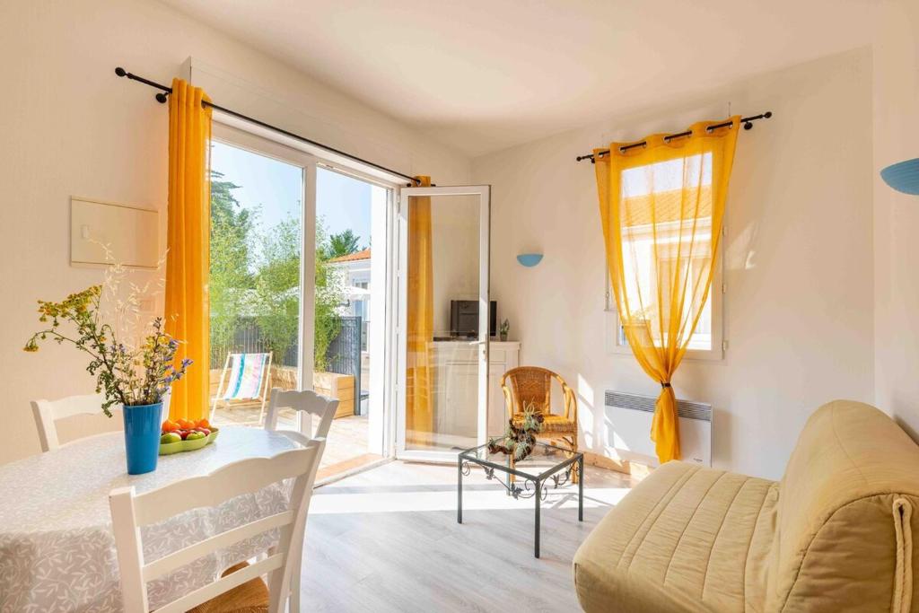 un salon avec un canapé, une table et une fenêtre dans l'établissement Appartement 350 m de la plage avec terrasse bois, à Saint-Jean-de-Monts