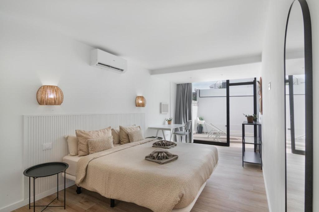 een witte slaapkamer met een bed en een woonkamer bij Chez Oti Puerto Rico in Puerto Rico de Gran Canaria