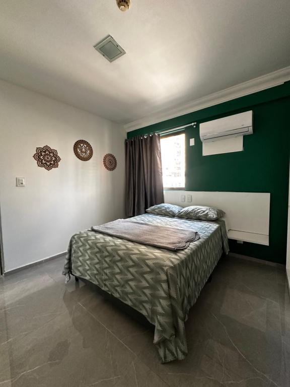 une chambre avec un lit et un mur végétal dans l'établissement Lindo Flat Boa Viagem 50m do Mar, à Récife