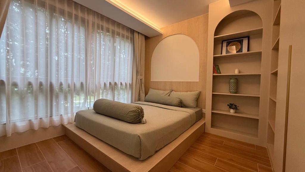 Una cama sentada en una habitación con ventana. en Fantasea Kamala Beach 1 BR 411, en Kamala Beach