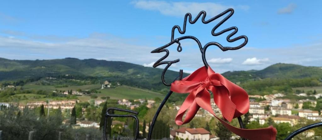 a red bow on a pole with a view of a city at Home in Tuscany in Greve in Chianti