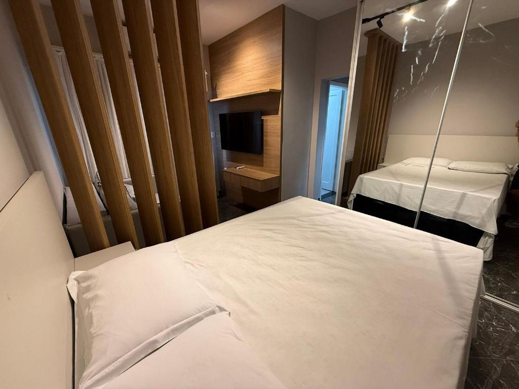 ein Hotelzimmer mit einem Bett und einem Spiegel in der Unterkunft Canal 3 lado da praia e R da Paz in Santos