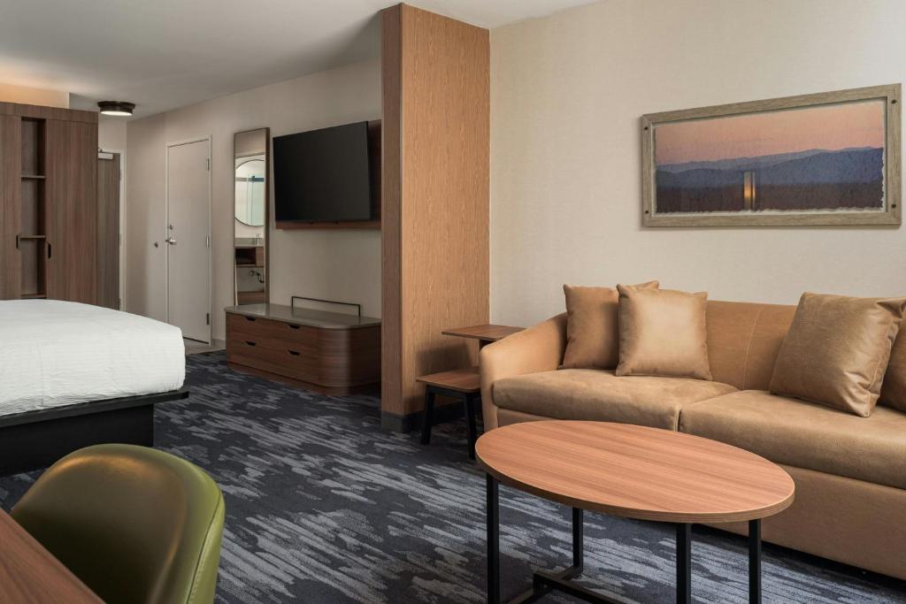 a hotel room with a couch and a bed at Fairfield by Marriott Inn & Suites Huntsville Madison in Madison