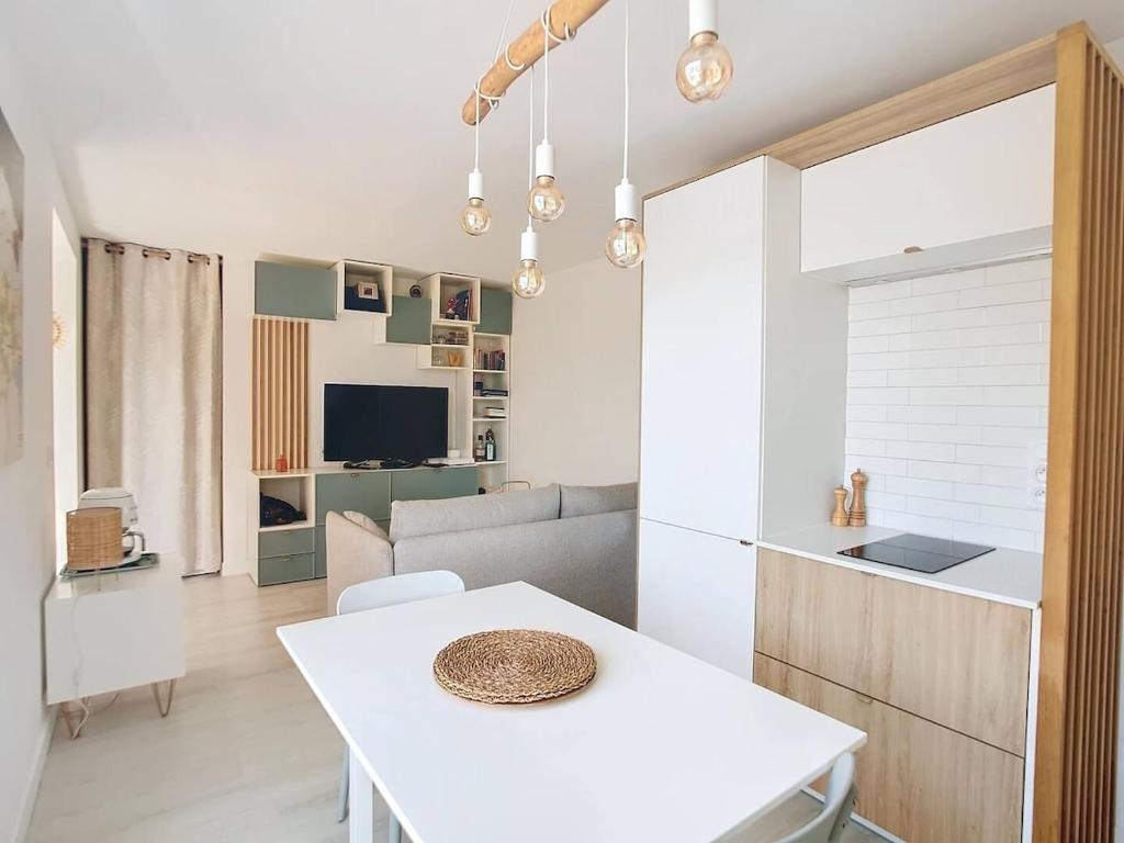 Il comprend une cuisine et un salon avec une table blanche. dans l'établissement Bright 2-room apartment - rooftop terrace - swimming pool, à Vallauris