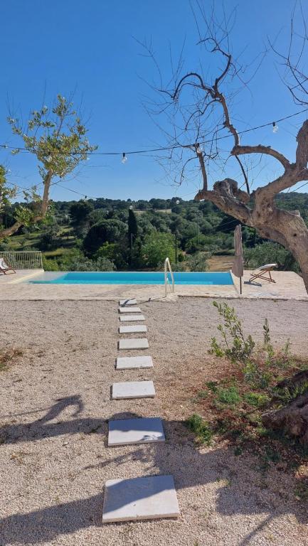 un chemin de passage à côté d'une piscine dans l'établissement Trullo Terra Bianca, à Ostuni