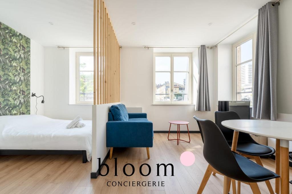 a bedroom with a bed and a table and chairs at Le cocon Place du Marché Nancy coeur de ville in Nancy