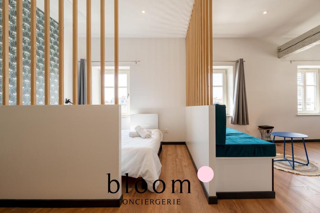 una habitación blanca con una cama y una silla en L'étoile Place du Marché central, en Nancy