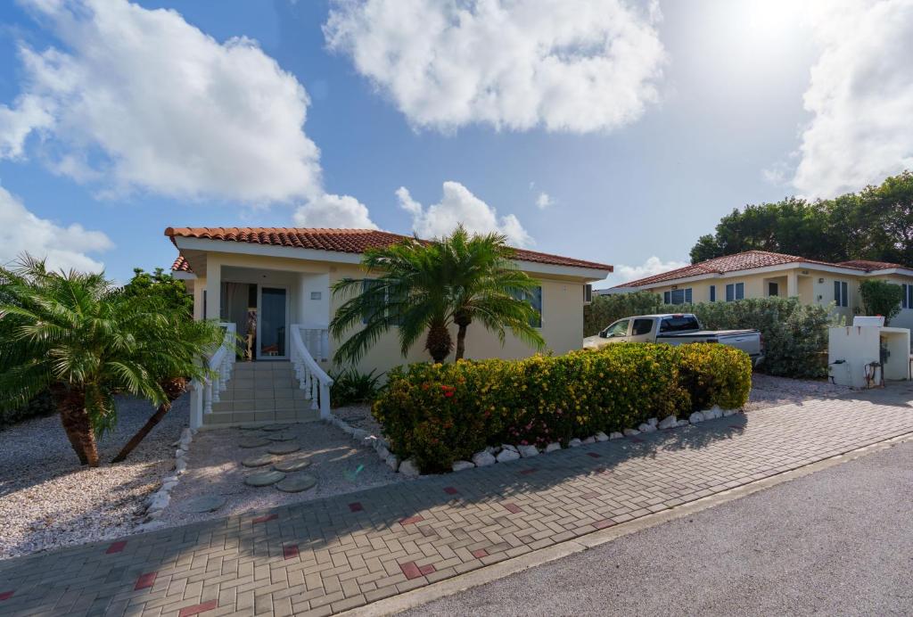 ein Haus mit Palmen und einer Auffahrt in der Unterkunft Family Home Jan Thiel op Marbella in Willemstad