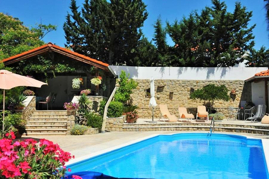 a swimming pool in a yard with a house at Apartments Angela in Kampor