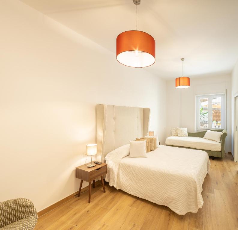 Un dormitorio blanco con dos camas y un sofá. en Mariannina Apartments - Maiori, en Maiori