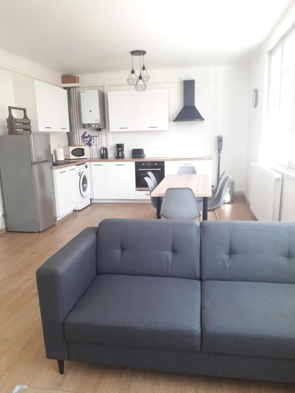 un salon avec un canapé et une cuisine dans l'établissement Appartement quartier du minck, à Calais