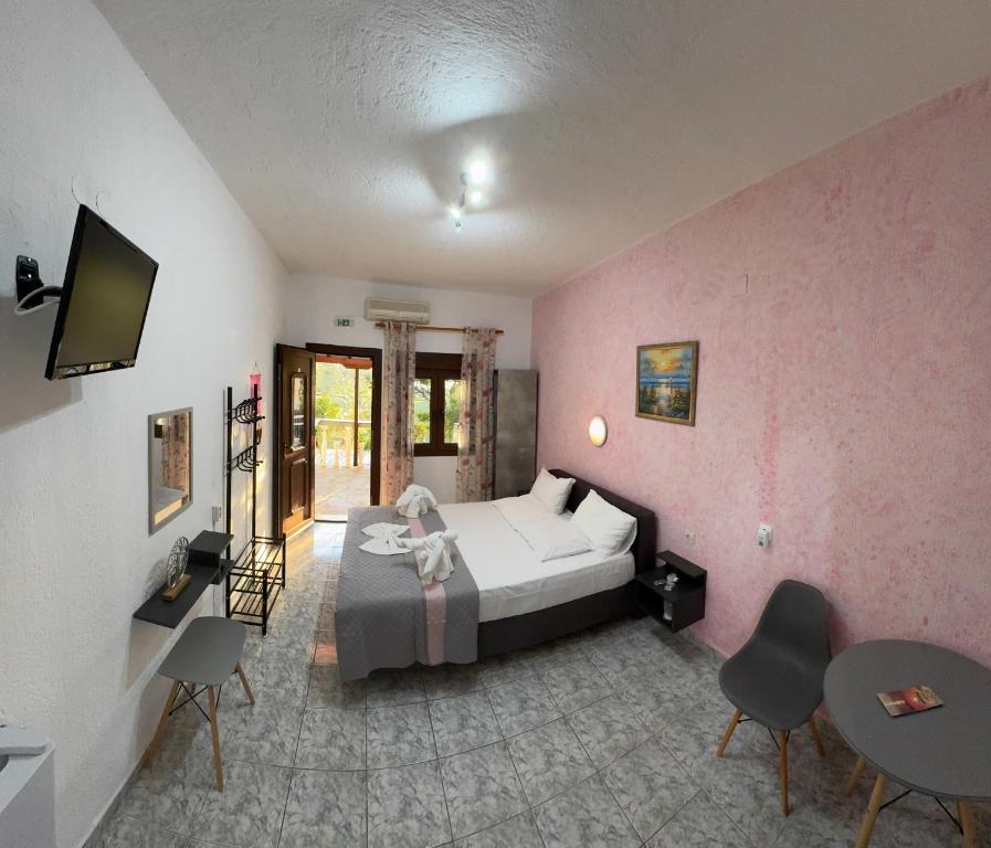 a bedroom with a bed and a tv and tables at Pelagos Beachfront in Panormos Skopelos