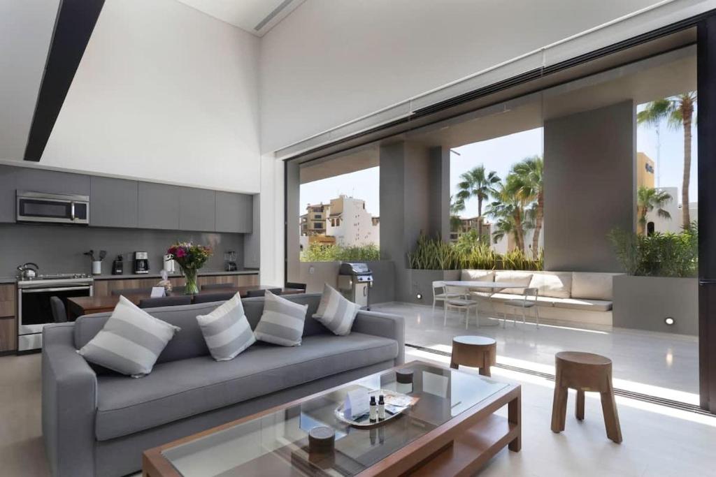 ein Wohnzimmer mit Couch und Tisch in der Unterkunft Cabo Marina 3 BR Loft Walk to Medano Beach in Cabo San Lucas
