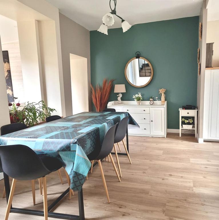 une salle à manger avec une table, des chaises et un miroir dans l'établissement KerMady, maison proche de la mer, à Saint-Malo