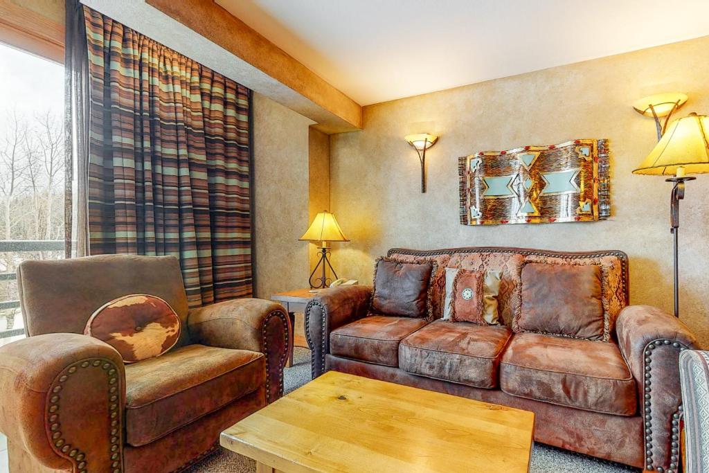 a living room with a couch and two chairs at Shoshone 1919 in Big Sky