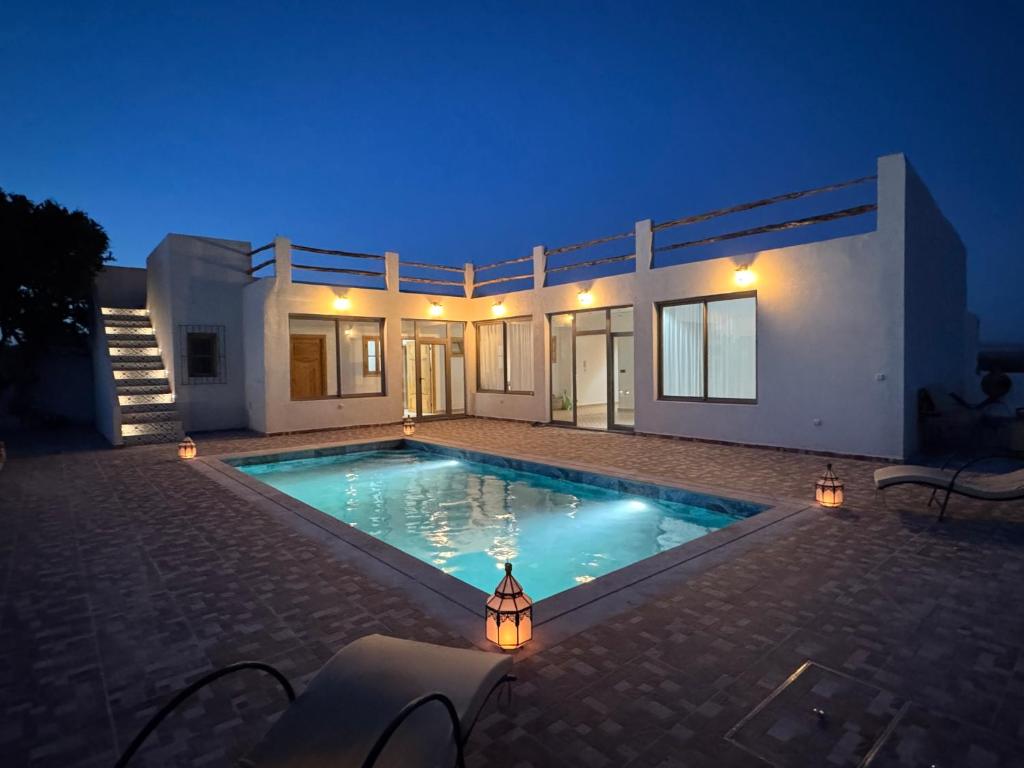 une piscine devant une maison la nuit dans l'établissement Sweety Mogador, à Essaouira