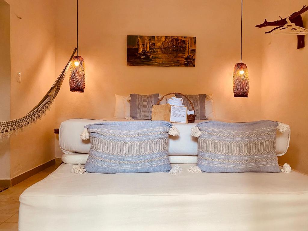 a living room with a white couch with two pillows at Hotel Para Ti - Adults Only in Holbox Island