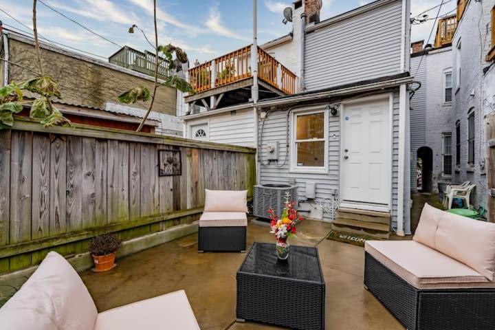 a patio with two chairs and a table at Charming Townhouse Sleeps 7 With Private terrace Garden in Baltimore