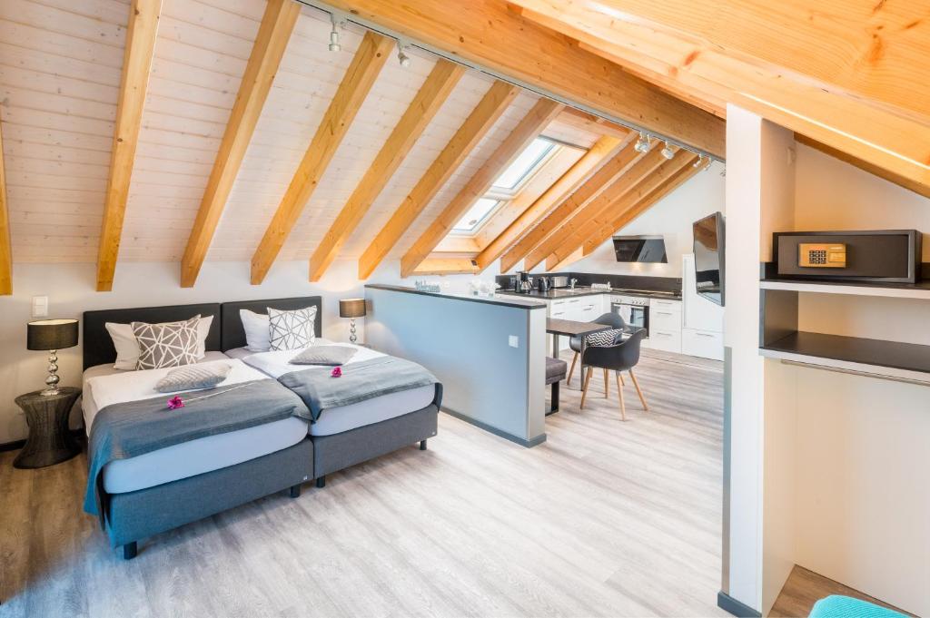a bedroom with a bed and a kitchen in a room at Design-Apartments by Ulrike Horster in Bensheim