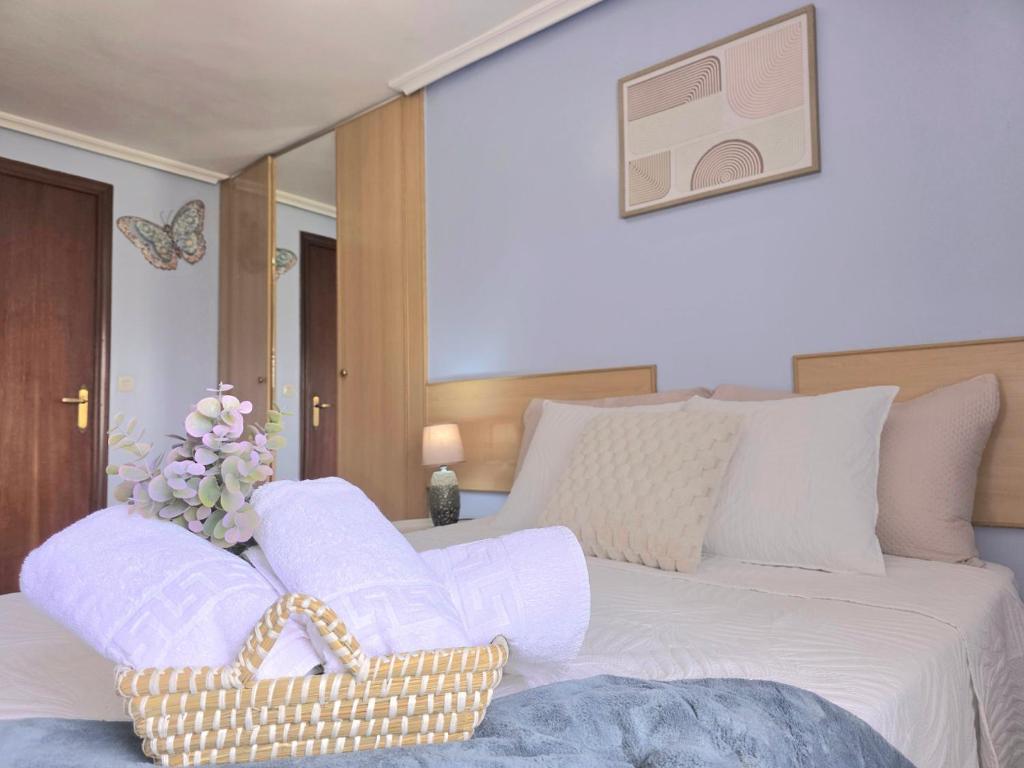 a bedroom with a white bed with a basket on it at La Casa de Lidya - 36802 in Entrambasaguas