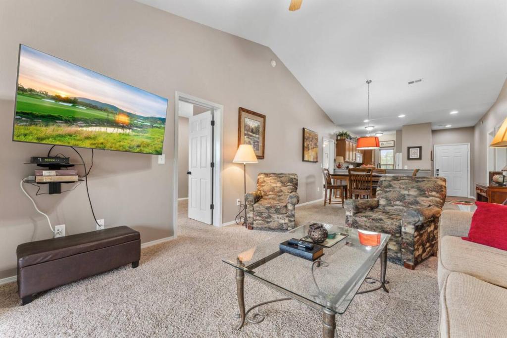 a living room with a couch and a tv on the wall at Golf View Luxe at Stonebridge in Branson West