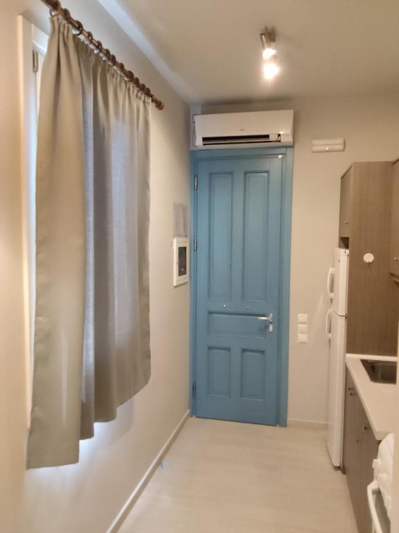 a blue door in a kitchen next to a refrigerator at Andros Guesthouses in Andros